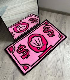 two pink rugs sitting on top of a wooden floor in front of a mirror