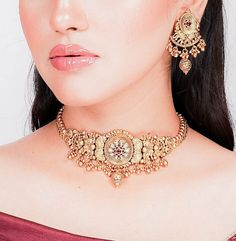 India necklace from Amrapali. This exquisite piece showcases the timeless allure of antique choker designs with a touch of Kundan jewelry elegance. Crafted with precision, it boasts intricate detailing and bears the hallmark of South India's rich jewelry tradition. This gold necklace is a testament to Amrapali's artistry in temple jewelry. Wear it to embody the grace and opulence of India's cultural heritage wherever you go. *𝐏𝐑𝐎𝐃𝐔𝐂𝐓 𝐃𝐄𝐓𝐀𝐈𝐋* * Material: Brass * Plating: Gold Plated Antique Choker Designs, Rich Jewelry, Amrapali Jewellery, Antique Choker, India Necklace, Temple Necklace, Kundan Jewellery Set, Choker Designs, Kundan Jewelry