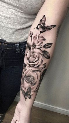 a woman's arm with roses and butterflies on it, in black and white