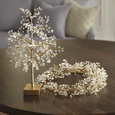 a table with a tree on top of it next to a pair of bracelets