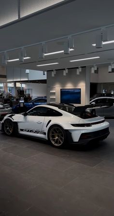 two white sports cars parked in a showroom