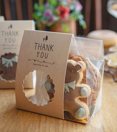 some cookies are sitting in a bag on a table with thank you tags attached to them