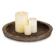 three lit candles on a wooden tray