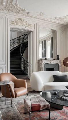 a living room filled with furniture and a spiral staircase in the backround area