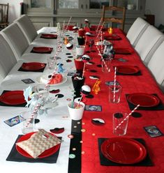 a long table set with red plates and place settings