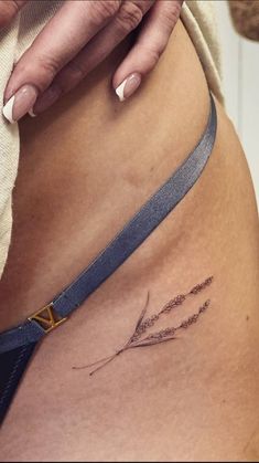 a woman's stomach with a small tattoo on the side of her belly and an arrow