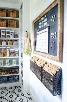 an organized pantry with chalkboard and baskets on the wall