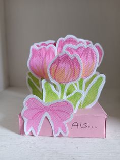 a card with pink flowers in a box