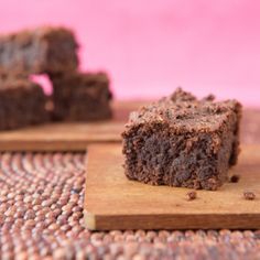 two pieces of brownie sitting on top of a wooden cutting board