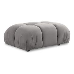 a grey ottoman with four pillows on it and one is folded up in the shape of an oval