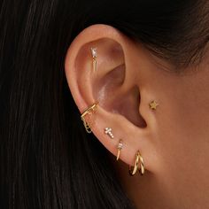 a close up of a person's ear with three different types of piercings