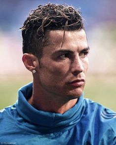 a close up of a soccer player wearing a blue shirt and earrings on his head