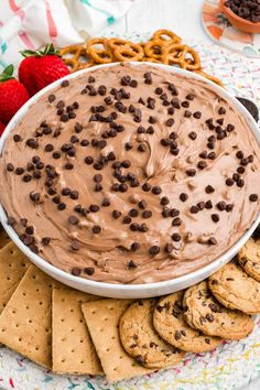 a chocolate dip surrounded by cookies and pretzels