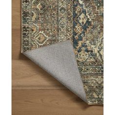 an area rug on the floor with a wooden floor and wood floors in the background