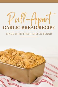 a loaf of garlic bread on top of a red and white striped towel with the title pull - apart garlic bread recipe made with fresh milled flour