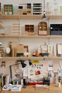 the shelves are filled with books, papers and other things on display in an art studio