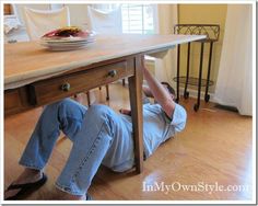 a person laying on the ground under a table