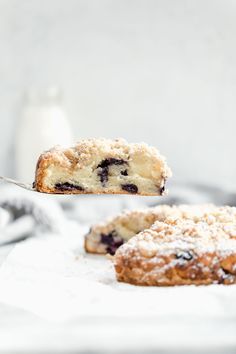 a piece of blueberry crumb cake being held by a fork