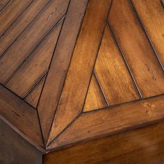 the corner of a wooden table that is made out of wood