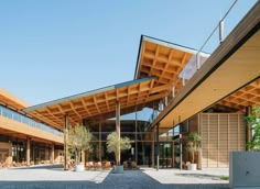 the outside of a large building with lots of wood and glass on it's sides