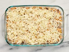 a casserole dish filled with cheese on top of a marble countertop,