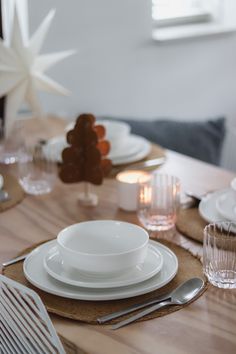 the table is set with white plates and silverware