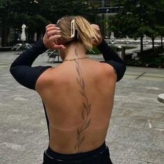 the back of a woman's body with tattoos on her upper and lower back