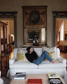 a woman sitting on top of a white couch