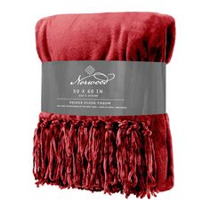 a red blanket with fringes on it and a label for the company's logo