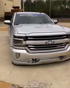 a silver truck parked in front of a building