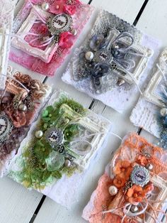 several different types of hair clips are laid out on a white wooden surface with beads and bows