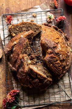 a loaf of bread sitting on top of a cooling rack next to an apple slice