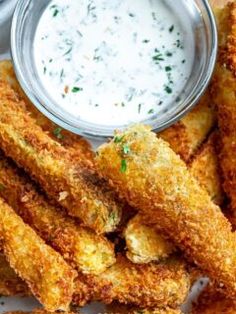 some fried food is on a plate with ranch dip in the middle next to it