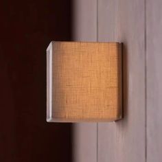 a light that is on the side of a wall next to a wooden paneled door