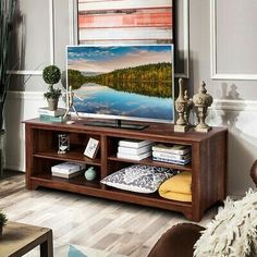 a living room filled with furniture and a painting on the wall above it's entertainment center