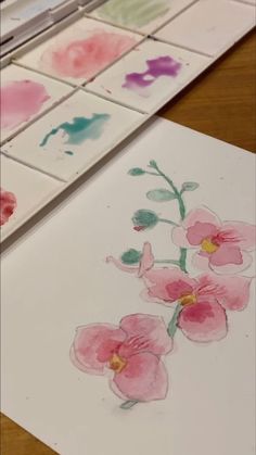 some watercolors are being used to paint flowers