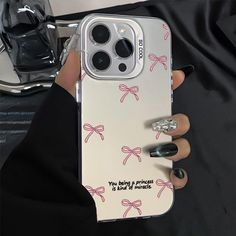 a woman's hand holding an iphone case with pink bows on it