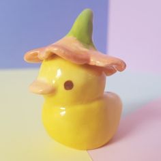 a yellow rubber duck with a green hat on it's head sitting on a table