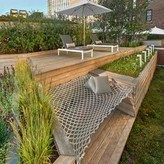 a deck with two lounge chairs and an umbrella