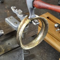 a metal object being worked on by a person with a hammer and some other tools