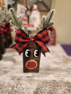 a wooden reindeer head with a red nose and plaid bow