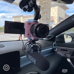 a dash camera mounted to the dashboard of a car with microphones in front of it