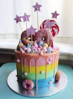 there is a colorful cake decorated with stars and candies on the top, as well as candy