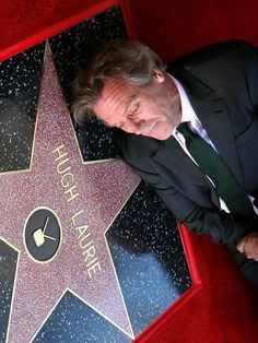 a man in a suit laying on top of a star