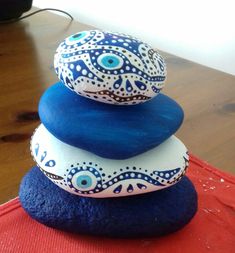 three rocks stacked on top of each other with an eye painted on the one rock