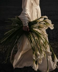 a woman in a white dress holding flowers