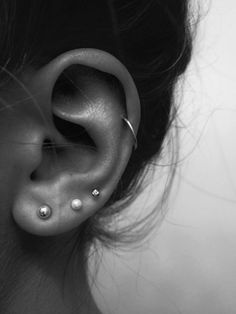 a woman's ear with two piercings on it