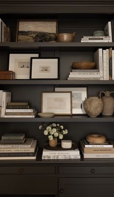 books, vases and pictures are on the shelves