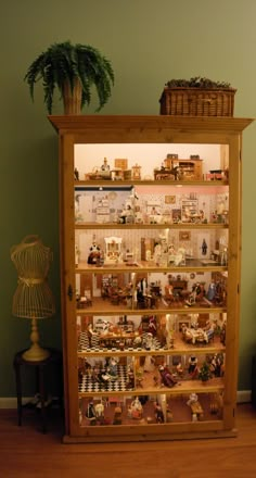 a wooden display case filled with lots of toy figurines on top of shelves