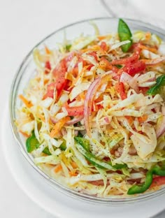 a salad in a glass bowl on top of a white table